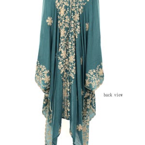 May include: Teal-colored embroidered kimono with a floral design. The back view of the garment is displayed, showcasing intricate beige embroidery. The kimono has long sleeves and a flowing silhouette, with the words "back view" visible.