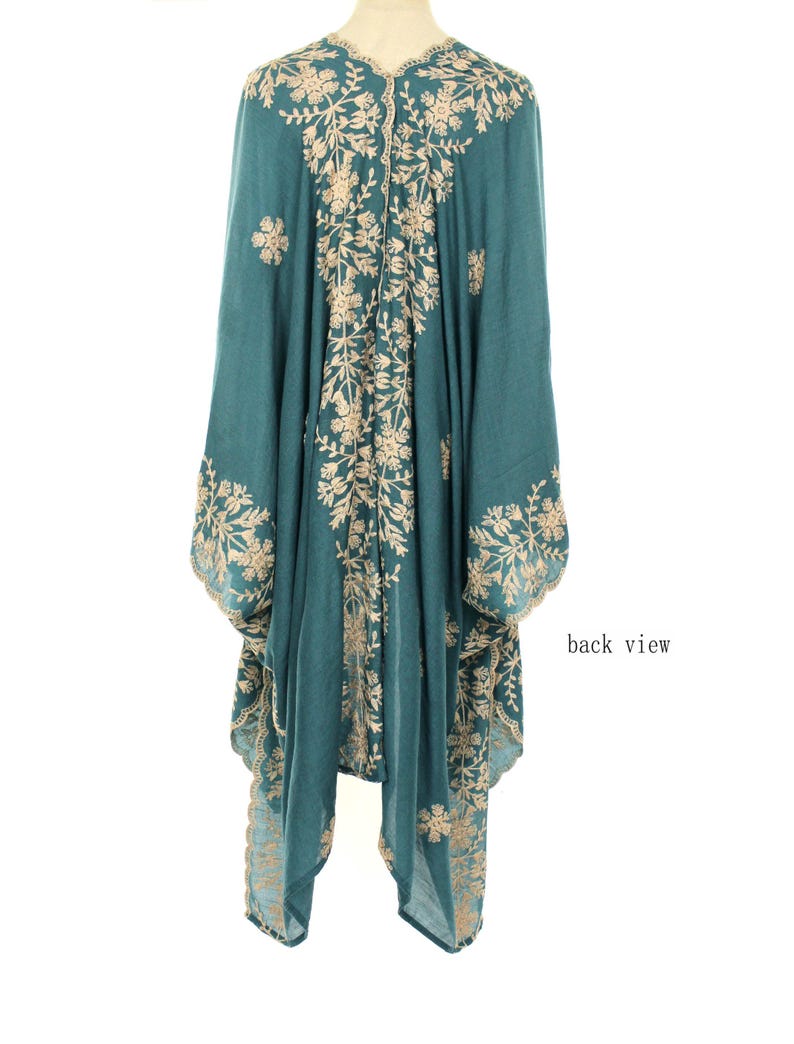 May include: Teal-colored embroidered kimono with a floral design. The back view of the garment is displayed, showcasing intricate beige embroidery. The kimono has long sleeves and a flowing silhouette, with the words "back view" visible.