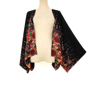 May include: Black kimono-style jacket with a floral print on the inside panels. The floral pattern features red, orange, and yellow flowers. The outer fabric is solid black.