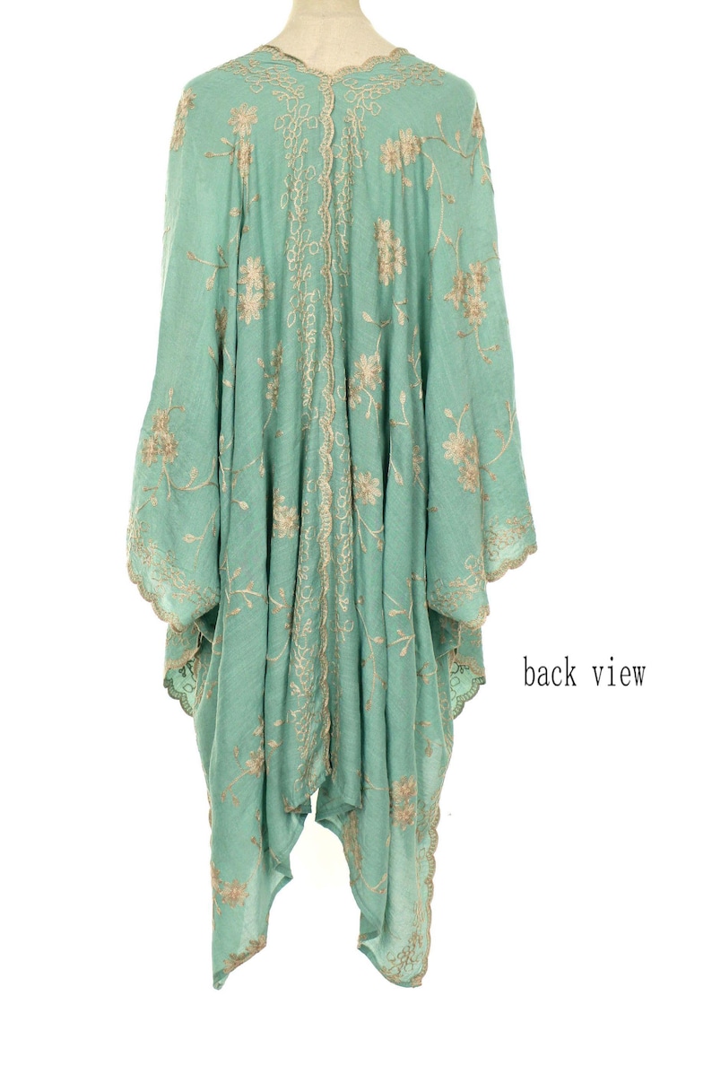 May include: A flowing, mint green garment with intricate gold floral embroidery. The back view reveals a detailed design along the center and edges, with the words "back view" visible on the right side. The fabric appears lightweight and airy.