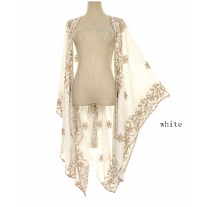 May include: A white open-front kimono-style wrap featuring intricate beige floral embroidery along the edges and throughout the fabric. The garment has wide, flowing sleeves and a scalloped hemline. The word white is printed on the right side.