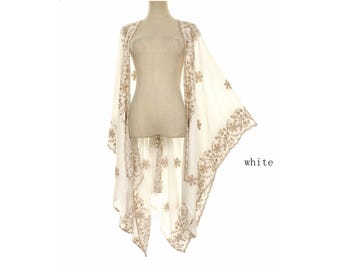 May include: A white open-front kimono-style wrap featuring intricate beige floral embroidery along the edges and throughout the fabric. The garment has wide, flowing sleeves and a scalloped hemline. The word white is printed on the right side.
