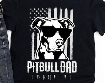 Könnte beinhalten: Schwarzes T-Shirt mit einem weißen amerikanischen Flaggen-Design und einer weißen Silhouette eines Pitbulls mit Sonnenbrille. Der Text "Pitbull Dad" ist in Weiß unter dem Bild gedruckt.