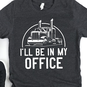 May include: A dark gray t-shirt with a white graphic of a semi-truck and the text "I'll be in my office".