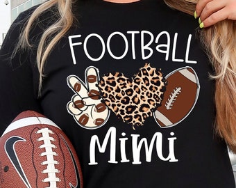 Könnte beinhalten: Schwarzes T-Shirt mit dem Text "Football Mimi" und einer Grafik eines Leopardenherzens mit Friedenszeichen und Fußbällen.