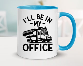 Puede incluir: Taza de cerámica blanca con borde y asa azules. La taza tiene un gráfico negro de un camión de comida con el texto "I'll be in -my- office" impreso en ella.