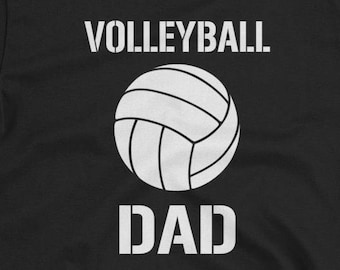 May include: Black t-shirt with the words "VOLLEYBALL" above a white volleyball graphic and the word "DAD" below. The design is printed in white on the front of the shirt. The shirt has short sleeves and a crew neck.