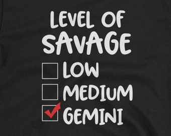 May include: Black t-shirt with white text that reads "Level of Savage" with a checkbox list below. The checkboxes are labeled "Low", "Medium", and "Gemini". The checkbox next to "Gemini" is checked.