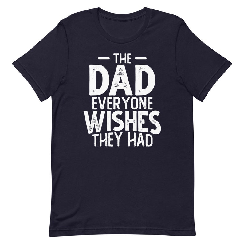 May include: Navy blue t-shirt with white text that reads "The Dad Everyone Wishes They Had".