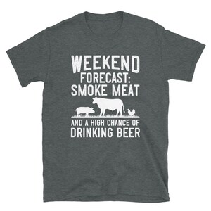May include: Dark heather grey t-shirt with a white graphic of a cow, pig, and chicken. The text on the shirt reads "Weekend Forecast: Smoke Meat and a High Chance of Drinking Beer."