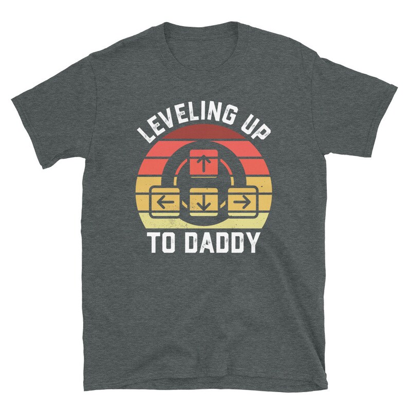 May include: A dark gray t-shirt with a retro-style graphic that says "Leveling Up To Daddy" with an arrow key design.