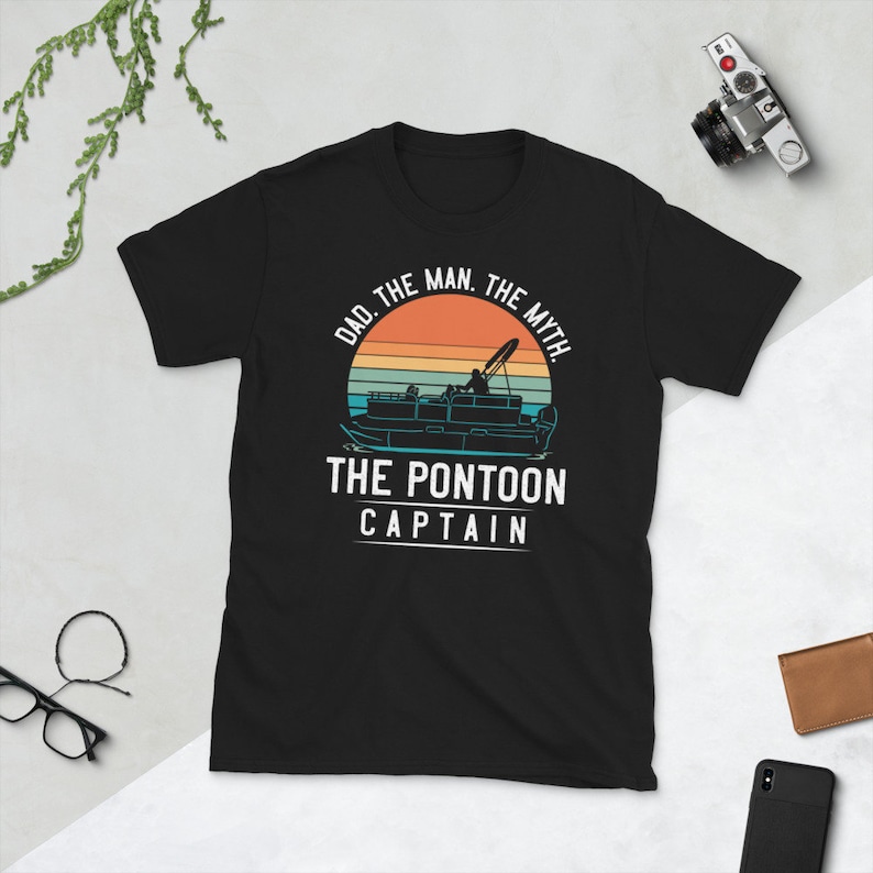May include: Black t-shirt with a retro sunset graphic and the text "Dad. The Man. The Myth. The Pontoon Captain."