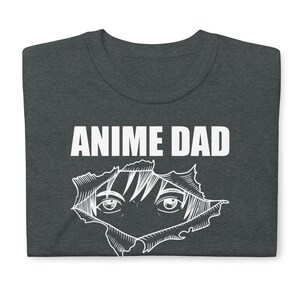 May include: Dark grey t-shirt with the text "Anime Dad" in white. A white outline of an anime character's eyes peeking out from a ripped hole in the shirt.