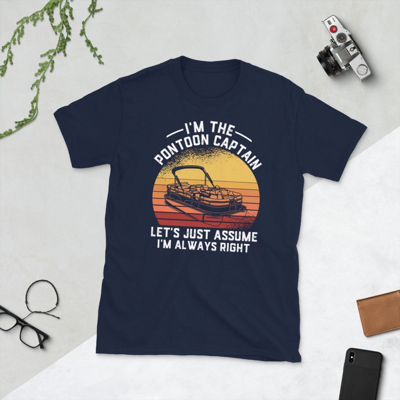 May include: Navy blue t-shirt with a retro sunset graphic of a pontoon boat. The text reads "I'm the Pontoon Captain. Let's just assume I'm always right."