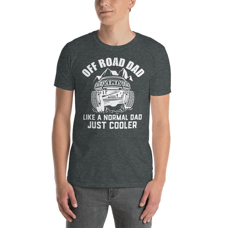 May include: A dark heather grey t-shirt with a white graphic of an off-road vehicle and the text "Off Road Dad Like a Normal Dad Just Cooler".
