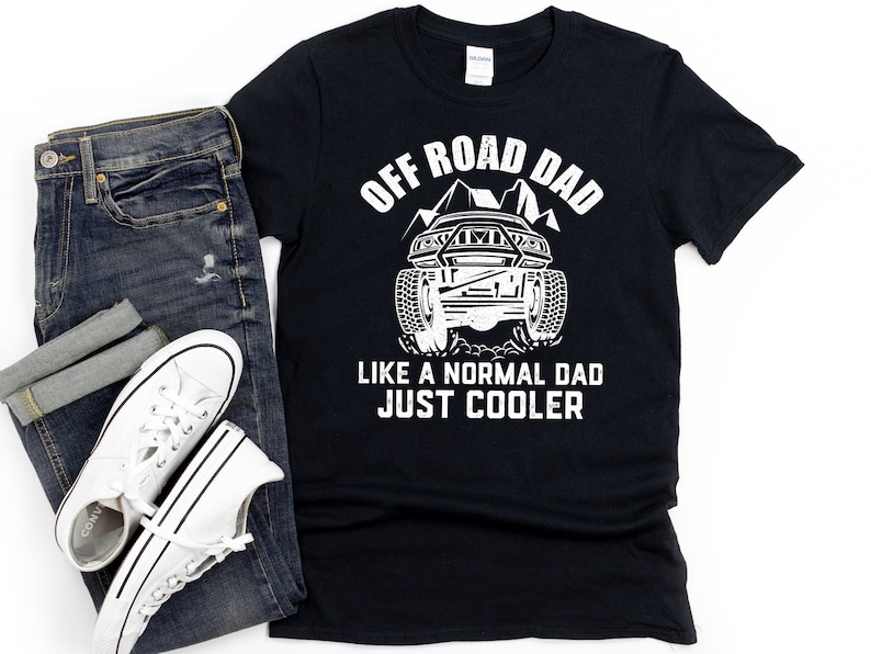 May include: Black t-shirt with white text that reads "Off Road Dad Like a Normal Dad Just Cooler". The shirt features a white silhouette of an off-road vehicle with mountains in the background.