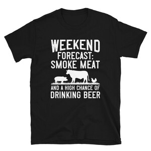 May include: Black t-shirt with white text that reads "Weekend Forecast: Smoke Meat and a High Chance of Drinking Beer". The shirt features a silhouette of a cow, pig, and chicken.