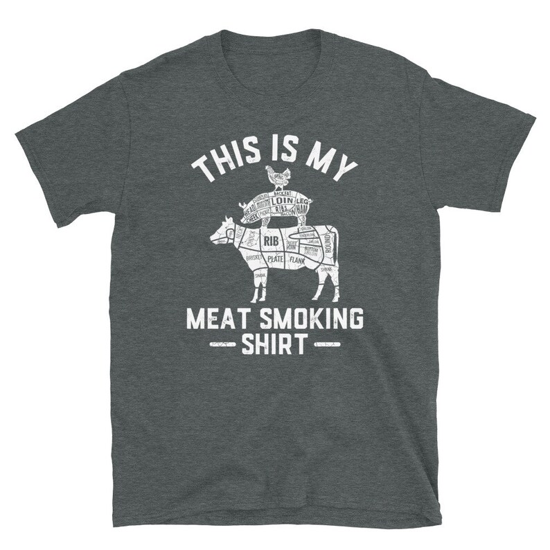May include: A dark heather grey t-shirt with a white graphic of a cow, pig, and chicken. The graphic is a diagram of the different cuts of meat on each animal. The text "This is my Meat Smoking Shirt" is printed below the graphic.
