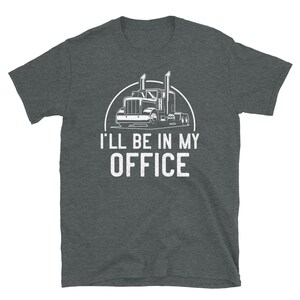 May include: A dark heather grey t-shirt with a white graphic of a semi-truck and the text "I'll be in my office".