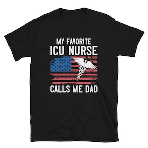 May include: Black t-shirt with a white American flag and a medical caduceus symbol. The text "My Favorite ICU Nurse Calls Me Dad" is printed on the shirt.