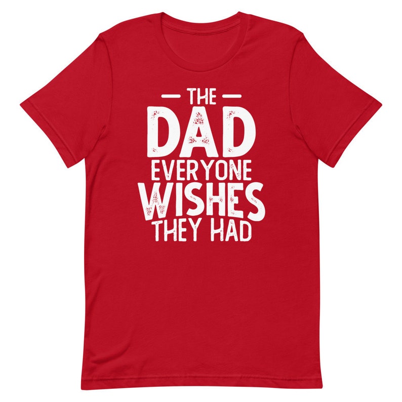 May include: Red short-sleeved t-shirt with white text that reads "The Dad Everyone Wishes They Had".