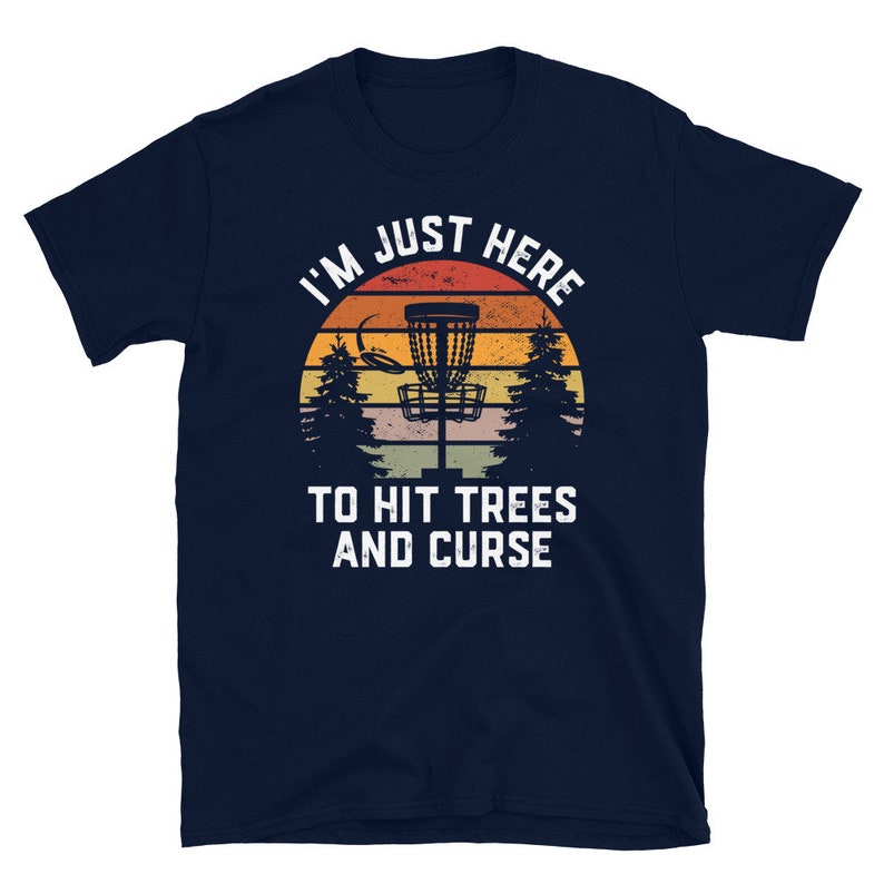 May include: A navy blue t-shirt with a vintage-style graphic of a disc golf basket and the text "I'm Just Here To Hit Trees And Curse".