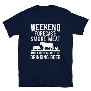 May include: Navy blue t-shirt with white text that reads "Weekend Forecast: Smoke Meat and a High Chance of Drinking Beer". The shirt features a silhouette of a cow, pig, and chicken.
