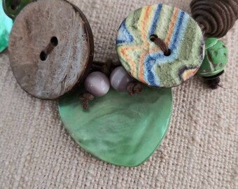 Necklace of yellow coconut wood buttons sewn on a dark brown waxed cotton drawstring.