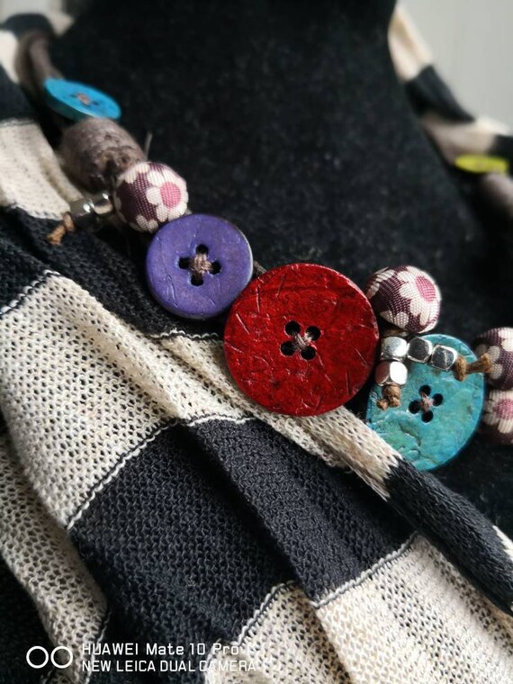 Necklace of yellow coconut wood buttons sewn on a dark brown waxed cotton drawstring.