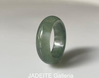 May include: A jadeite ring with a light green color and a smooth, polished finish. The ring is a simple band with a rounded shape.