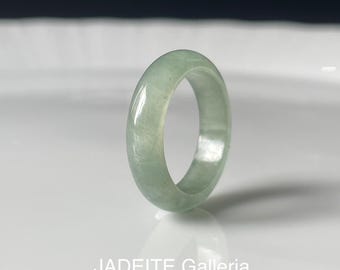 May include: A pale green jadeite ring with a smooth, polished finish. The ring is a simple band with a rounded shape.