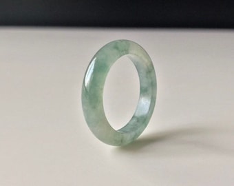 May include: A light green jade ring with a smooth, polished finish.