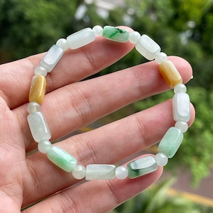 May include: A jade bracelet with rectangular beads in shades of green and yellow.