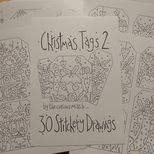 May include: A collection of white paper Christmas tags with black line drawings. The central tag reads "Christmas Tags 2" and "30 Stitchery Drawings". Other tags feature festive designs like reindeer, ornaments, and stockings.