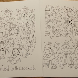 Op de afbeelding: Twee pagina's Halloween-kleurboekpagina's met grillige illustraties. Eén pagina heeft een hartvormig ontwerp met de woorden "Trick or Treat" en verschillende Halloween-elementen. De andere pagina heeft vergelijkbare illustraties. De tekst "Trick or Treat by the Curious miss b..." staat onderaan.