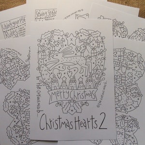 Puede incluir: Patrón imprimible en blanco y negro para un diseño de corazón navideño con un reno, casas y el texto "Feliz Navidad". El patrón se titula "Christmas Hearts 2" y es de "the curious miss b."