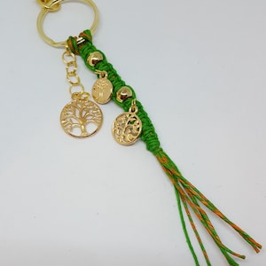 May include: Green and orange string keychain with gold tree of life charms and beads.