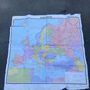 May include: A vintage political map of Europe with a blue background and coloured borders for each country. The map is titled "Европа" in Cyrillic script and "ПОЛИТИЧНАЯ КАРТА" in Cyrillic script. The map is printed on white paper and has a scale of 1:20,000,000.