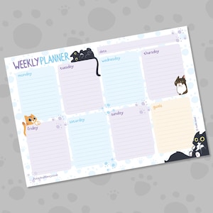 May include: A weekly planner with a light blue and white background, featuring cartoon cat illustrations. The planner has sections for each day of the week, with the words "Weekly Planner" at the top. The planner also has a section for goals.