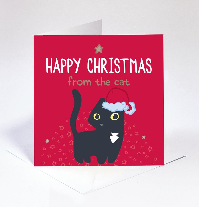 Op de afbeelding: Een vierkante wenskaart met een felrode achtergrond en een zwarte kat met een rood-witte kerstmuts. De tekst luidt "HAPPY CHRISTMAS from the cat" in witte en bruine letters. Het ontwerp is voorzien van kleine sterpatronen.