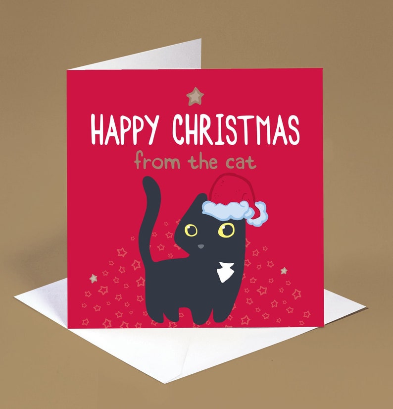 Op de afbeelding: Een vierkante wenskaart met een rode achtergrond en een zwarte kat met een rood-witte kerstmuts. De tekst HAPPY CHRISTMAS from the cat staat in witte en grijze letters op de kaart. Kleine sterretjes zijn verspreid over het onderste rode deel.