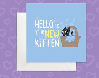May include: A square greeting card with a light blue background featuring a black kitten with large yellow eyes sitting in a brown woven basket with a blue blanket. The text reads HELLO TO YOUR NEW KITTEN in white and yellow letters.