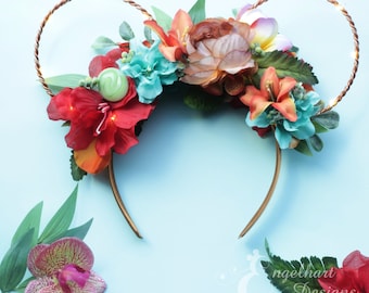 May include: Floral headband with a gold wire frame and a green swirl charm. The headband is decorated with red, orange, yellow, and blue flowers.