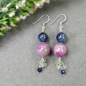 May include: A pair of dangle earrings with blue and pink gemstone beads and smaller blue gemstone accents.
