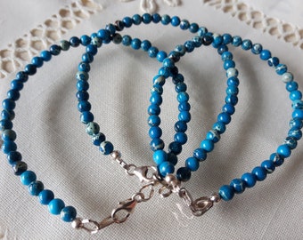 Puede incluir: Tres pulseras de jaspe azul y blanco con cierres de plata. Las pulseras están hechas de pequeñas cuentas redondas.