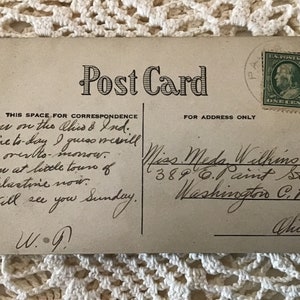 May include: A vintage postcard with a handwritten message. The message reads: "Am on the Ches & Ind. line to day I guess mervill go over to-monow. Am at little tours of Palestine now. Will see you Sunday. W.G." The address on the postcard is: "Miss Meda Withing 389 0.1 aint St. Washington C.H. Ohio."