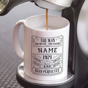 May include: White ceramic coffee mug with black text that reads "The Man The Myth The Legend NAME 1921 Genuine Quality One of a Kind Limited Edition Aged Perfectly".