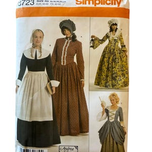 May include: A Simplicity sewing pattern envelope 3723 for historical costumes in sizes 14-22. The front displays four variations of long dresses with bonnets, aprons, and accessories, featuring floral and solid fabrics in brown, black, and yellow.
