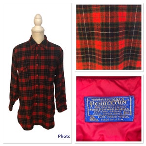 May include: A red and black plaid flannel shirt with a button-down collar and long sleeves. The shirt has a label that reads "WARRANTED TO BE A PENDLETON" and "PENDLETON WOOLEN MILLS PORTLAND, OREGON 100% VIRGIN WOOL 162 PURE VIRGIN WOOL MADE IN U.S.A."