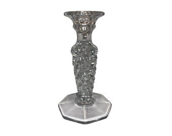 Peut inclure: Bougeoir en verre transparent avec un motif texturé en forme de bulles sur la tige. La base est une forme octogonale claire et facettée. Le dessus a un design évasé et circulaire pour tenir une bougie.